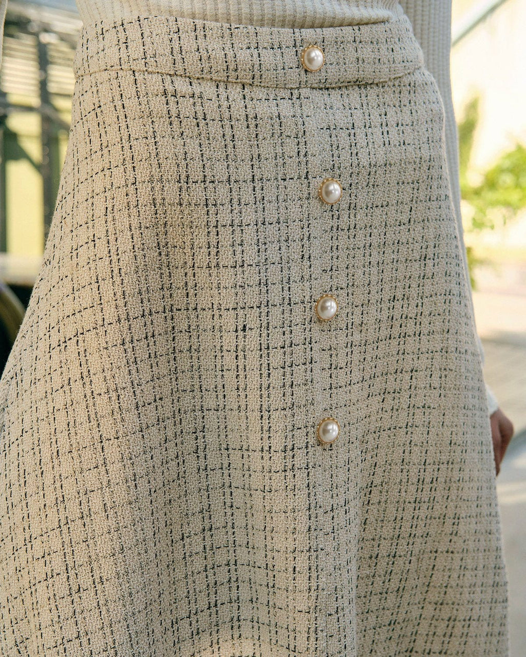 La falda de tweed de cintura alta con botones de perla