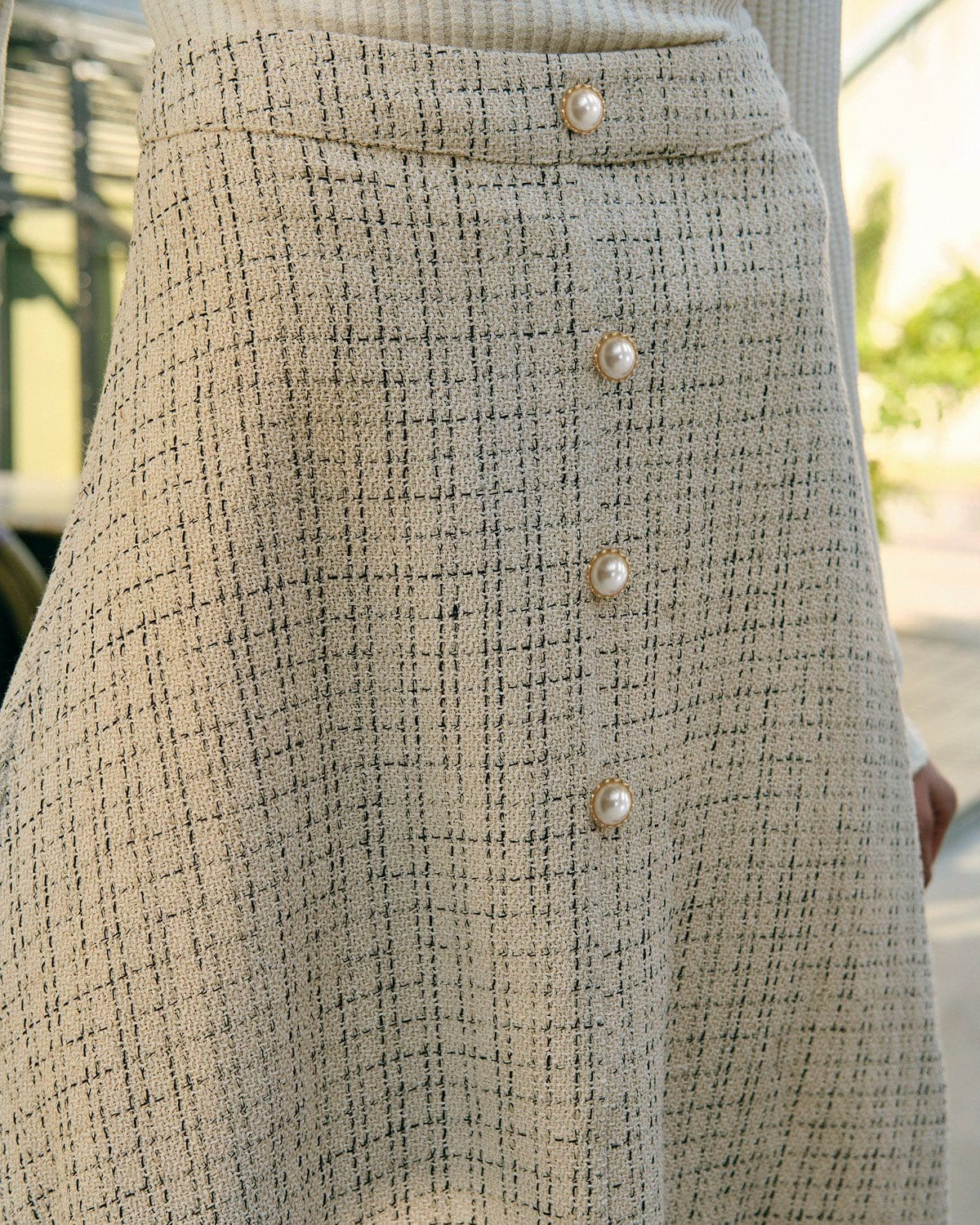 La falda de tweed de cintura alta con botones de perla