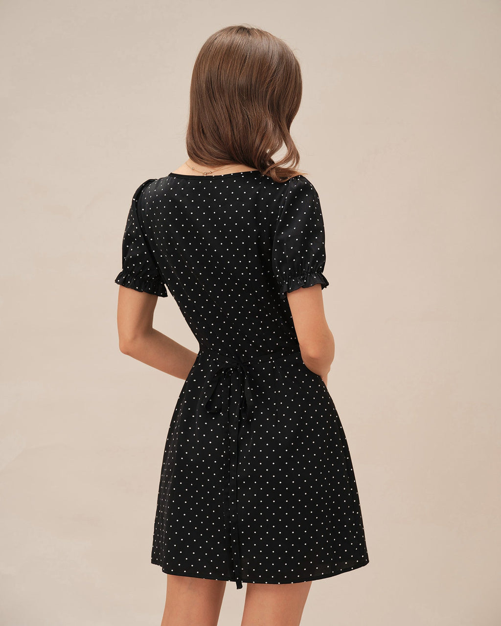 Vestido corto negro con lunares y escote en V