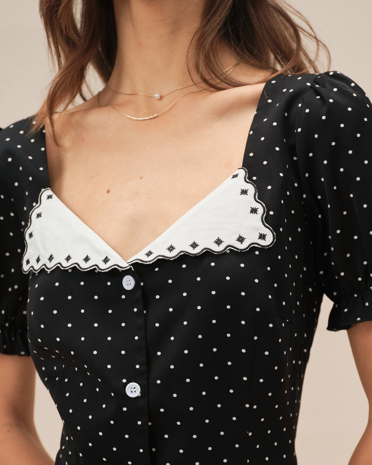 Vestido corto negro con lunares y escote en V